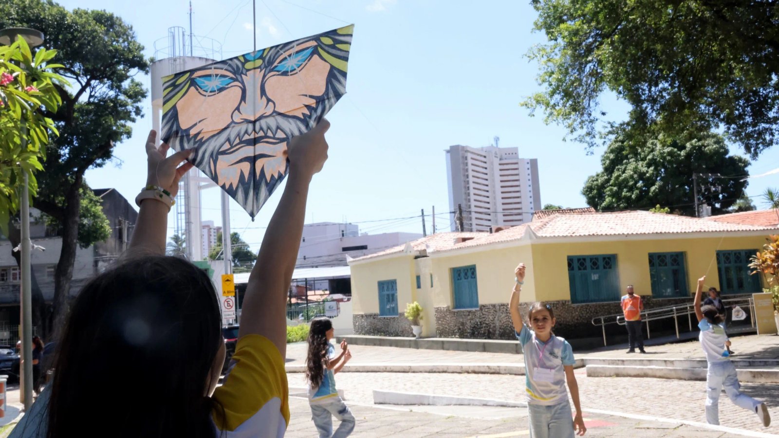 duas meninas com a farda da prefeitura brincando com pipas